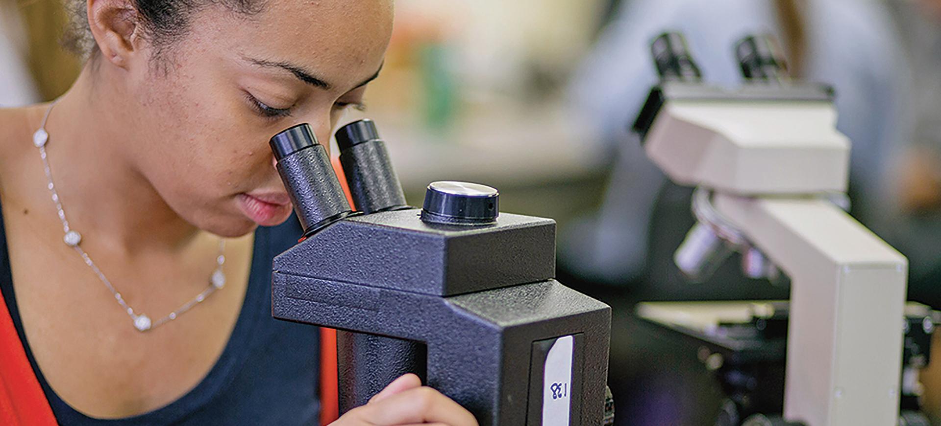 一个学生通过显微镜看东西