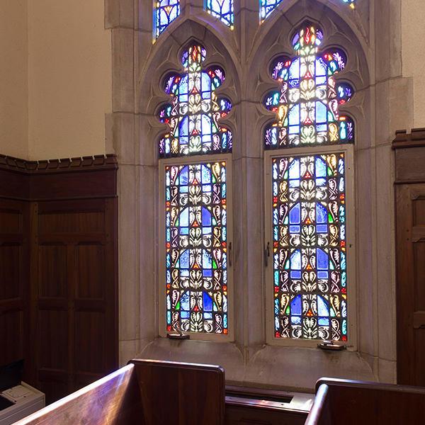 stained glass windows with a church pew