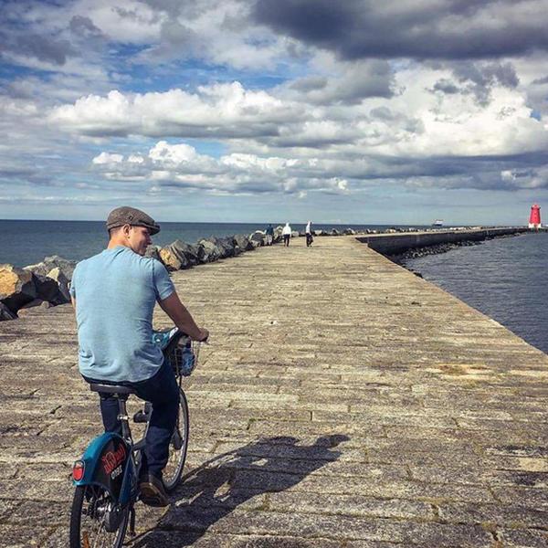 一个年轻人在海边的码头上骑自行车