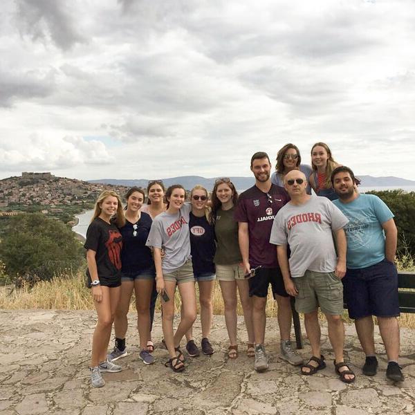 a group of students and a male professor on a hilltop in Greece