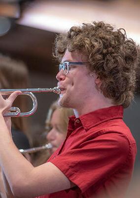 orchestra member playing a brass instrument
